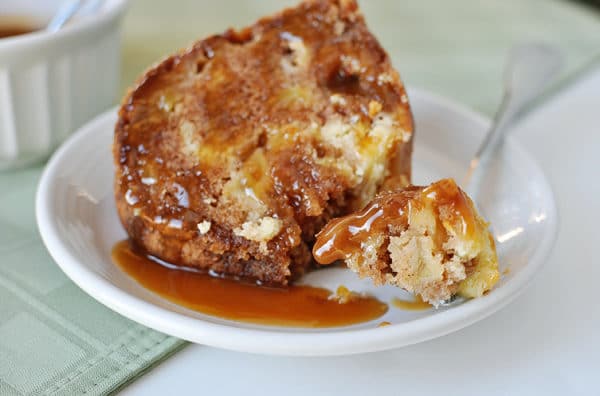 Small white plate with a piece of caramel apple bundt cake with a bite taken out.