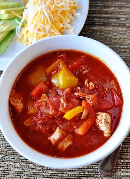 Top view of a white bowl filled with red chicken chili.