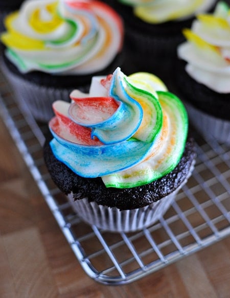 Top view of chocolate cupcakes with tie-dye frosting on a cooling rack.