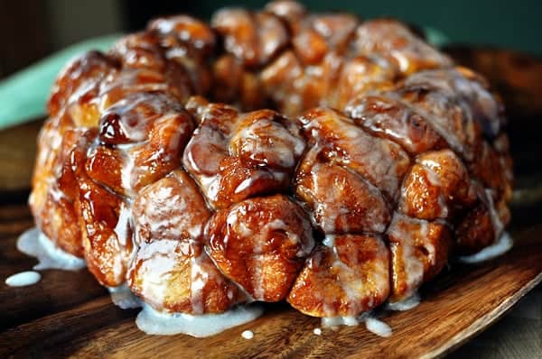 A bundt-pan shaped mass of cooked, gooey monkey bread on a cutting board. 
