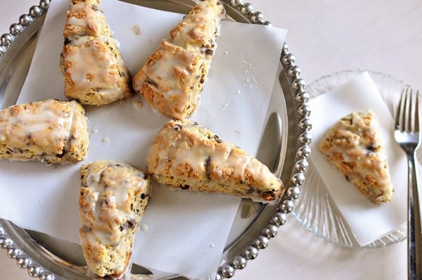 top view of glazed chocolate chip scones on a silver serving platter