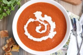 the best classic tomato soup in white bowl with swirl of heavy cream