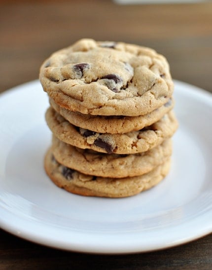 Stack of chocolate chip cookies on a white plate.