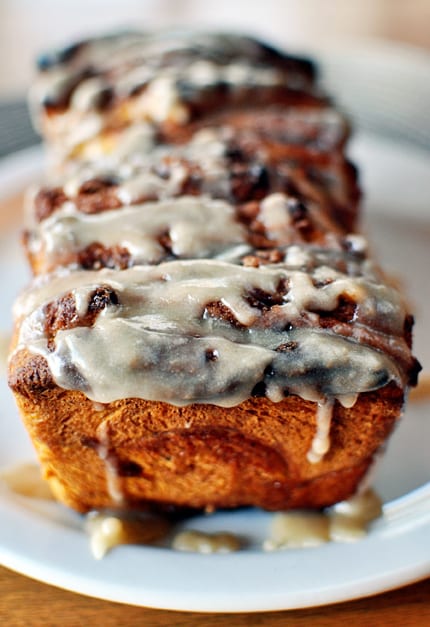 Pieces of glazed pumpkin pull-apart bread on a white plate.