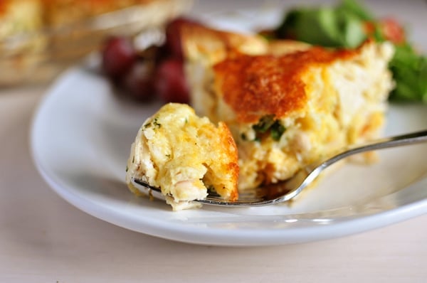 A slice of cheesy chicken quesadilla pie with a bite being taken out.