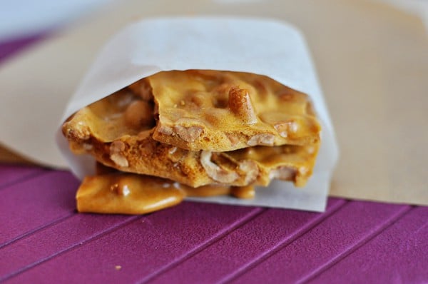 Pieces of peanut brittle inside a parchment paper.