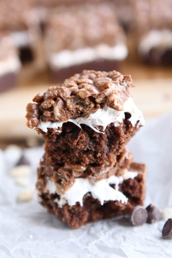 Killer crunch brownie broken in half and stacked on white parchment paper.