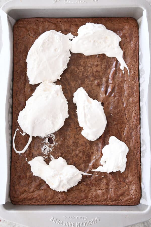 Marshmallow cream dolloped across top of warm pan of brownies.