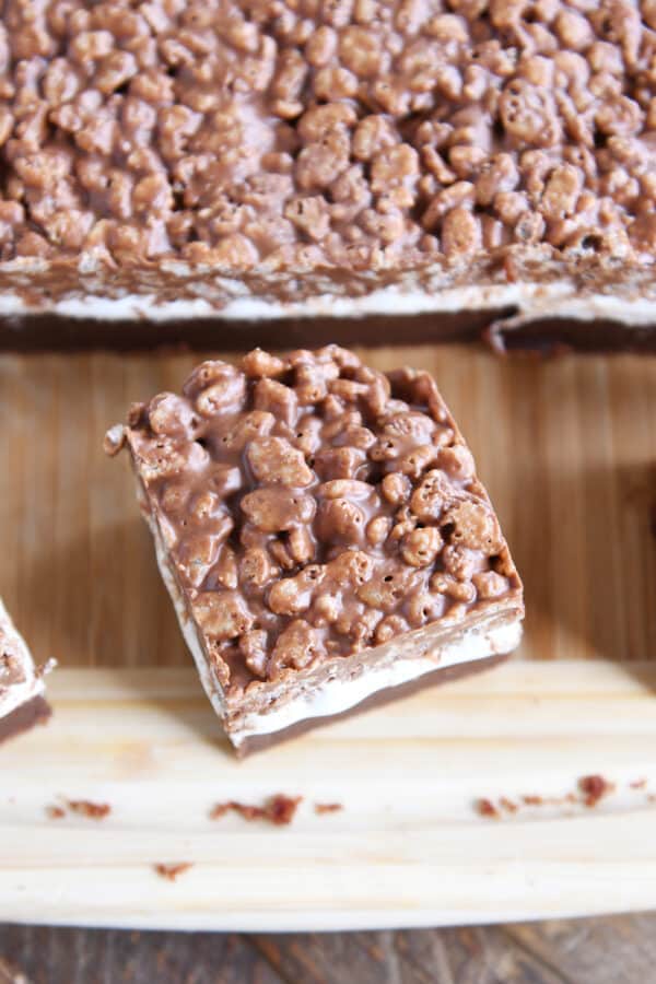 Brownie square on wood cutting board.