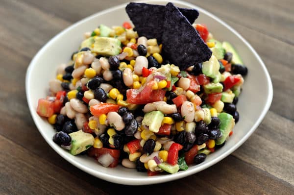 a white bowl full of bean, corn, and avocado dip