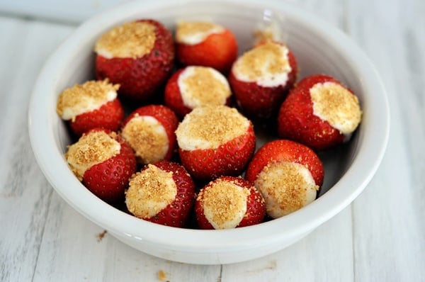 White bowl full of cheesecake stuffed strawberries.