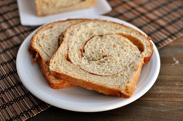 Two pieces of cinnamon swirl bread on a white plate.