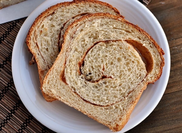 Top view of two pieces of cinnamon swirl toast on a white plate.