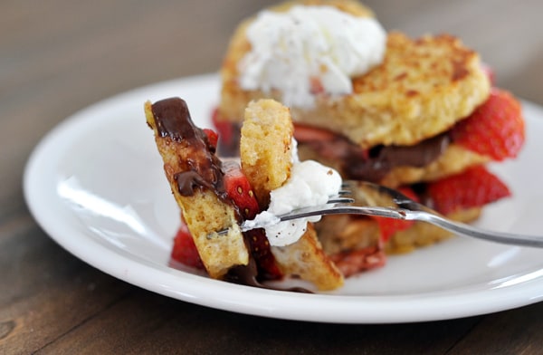 chocolate and strawberry stuffed french toast with a fork taking a bite out