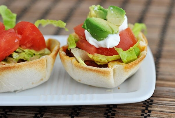 Two mini tortillas filled with taco meat and taco toppings.