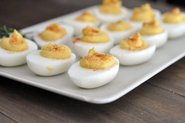 A white rectangular platter filled with deviled eggs.