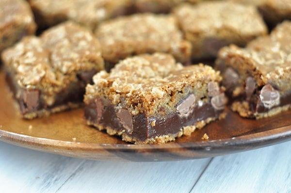 A plate of fudge filled chocolate chip cookie bars cut into squares.