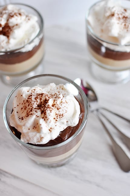 Top view of layered peanut butter and chocolate puddings topped with whipped cream.