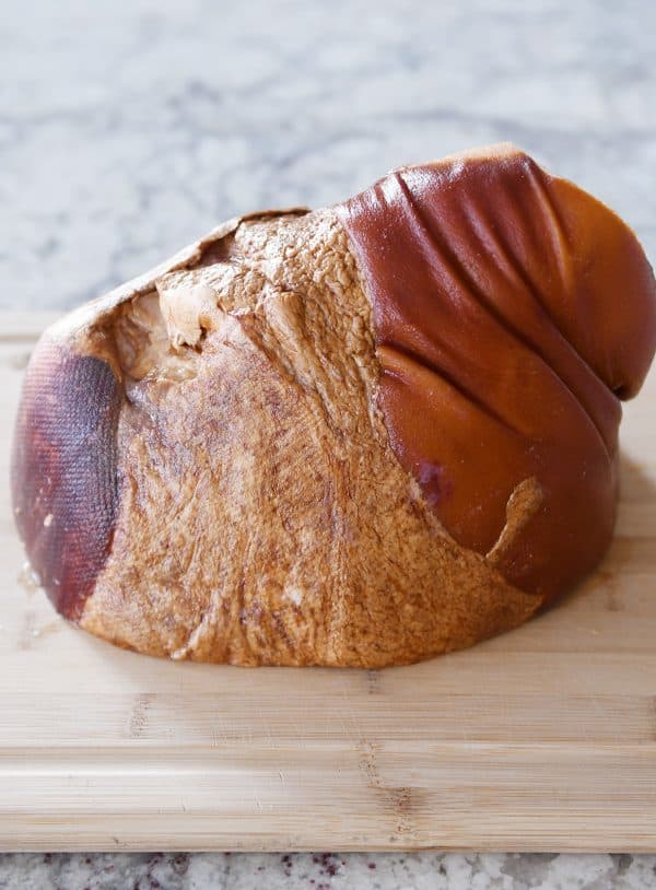 Bone-in ham on cutting board.