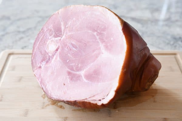 Bone-in ham on cutting board.