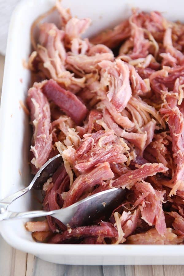 Shredded sweet baked ham in white baking dish.