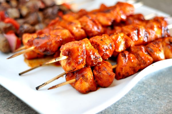 White platter with BBQ chicken kebabs and beef kebabs.