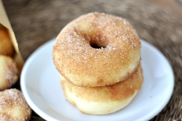 A white plate with two baked doughnuts stacked on top of each other.