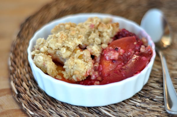 White ramekin with baked blackberry nectarine crumble.