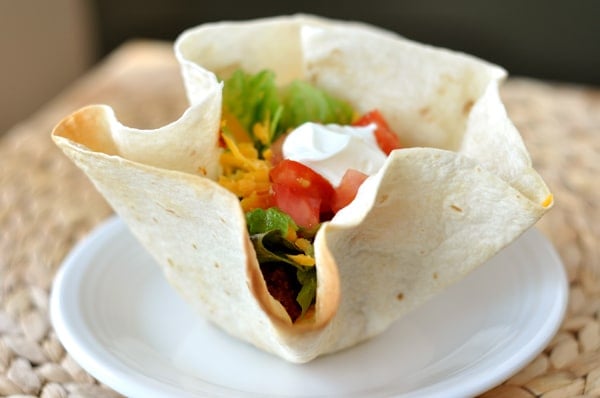 Tortilla bowl filled with taco meat and toppings.