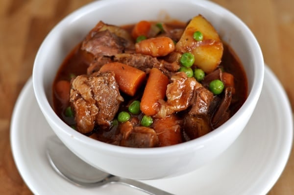 White bowl full of beef and vegetable stew.