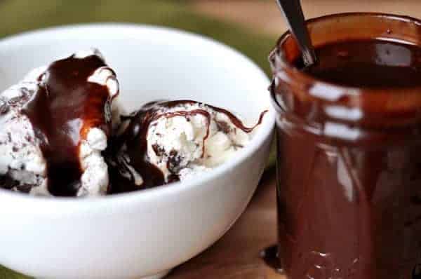 White bowl filled with vanilla ice cream and hot fudge sauce.