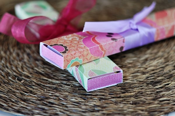 two colorful long paper boxes with ribbons tied in the middle