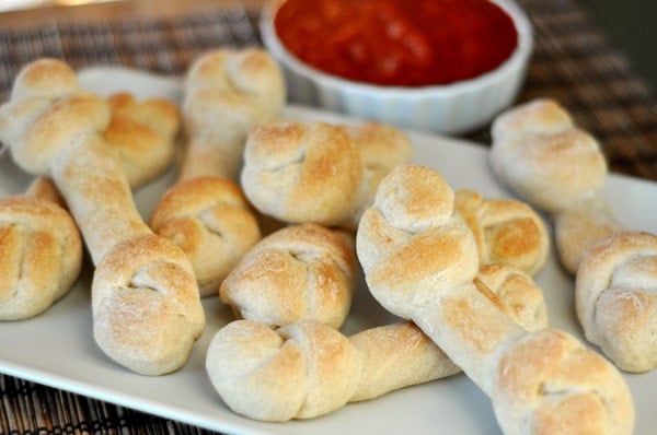 A white rectangular platter filed with breadstick-shaped bones.