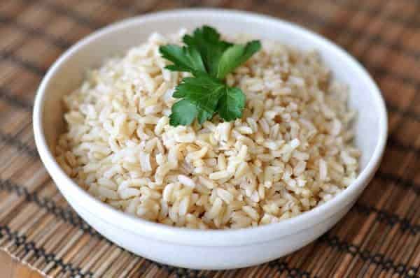 White bowl full of baked brown rice.