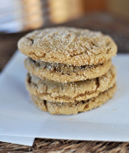A stack of four sugar-coated brown sugar cookies on a piece of parchment.
