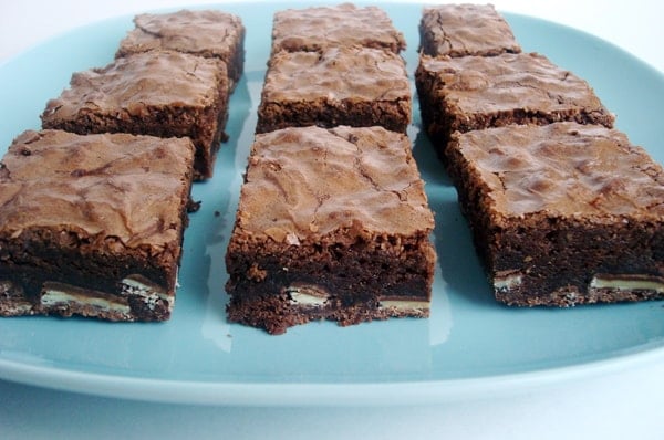 Nine cut up mint brownies on a blue plate.