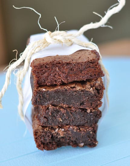 A stack of four brownies tied up with twine. 