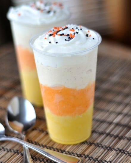 Two milkshakes in plastic glasses with layers to look like a candy corn.