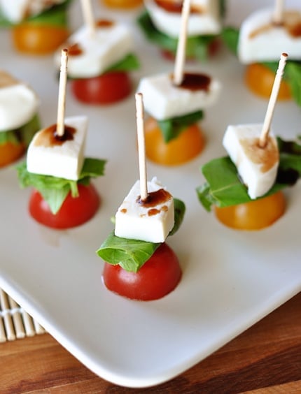 White platter with toothpick caprese skewers.