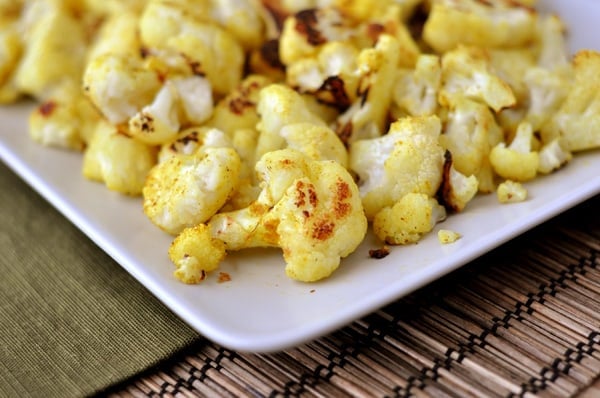 a white platter with baked cauliflower florets