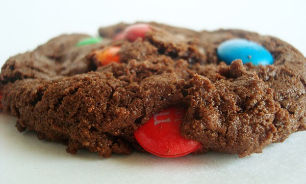 Side view of a chocolate cookie sprinkled with M&M's.