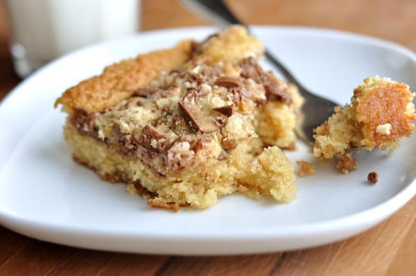 A slice of toffee-topped cake on a white plate.