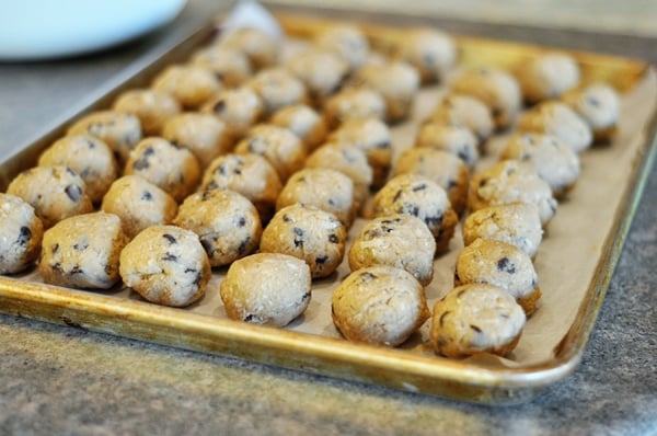 a cookie sheet full of chocolate chip cookie dough balls