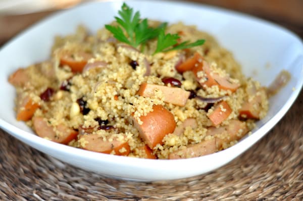 White oval bowl filled with a chicken sausage couscous salad.