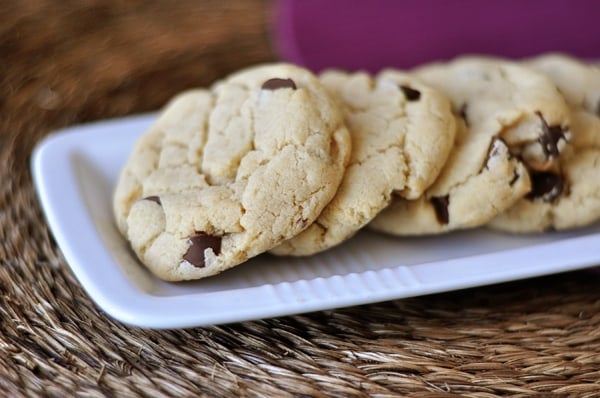 Chocolate chip cookies lined up next to each other on a white rectangular platter.