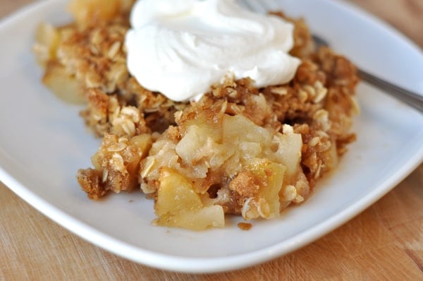 A white plate with cooked apple crisp.