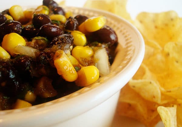 corn and black bean salsa on a plate with tortilla chips on the side