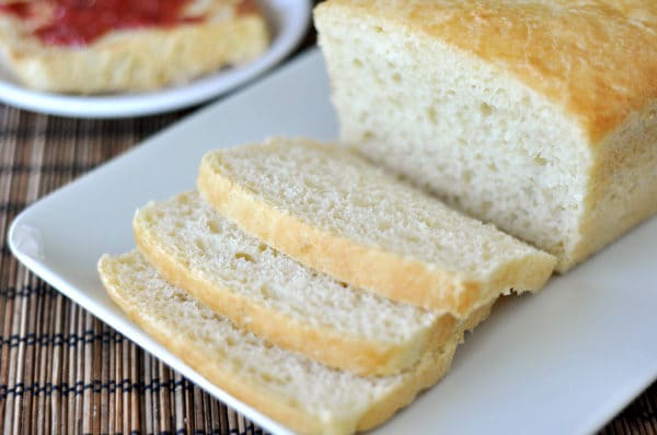 Sliced white english muffin bread on a white platter.