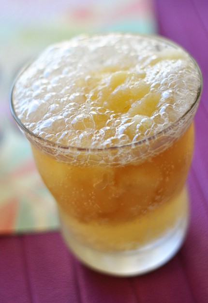 A glass full of citrus fruit slush.