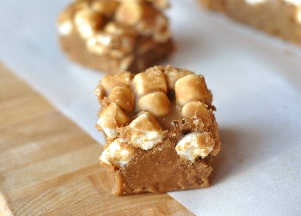 Top view of two squares of light colored fudge topped with marshmallows.